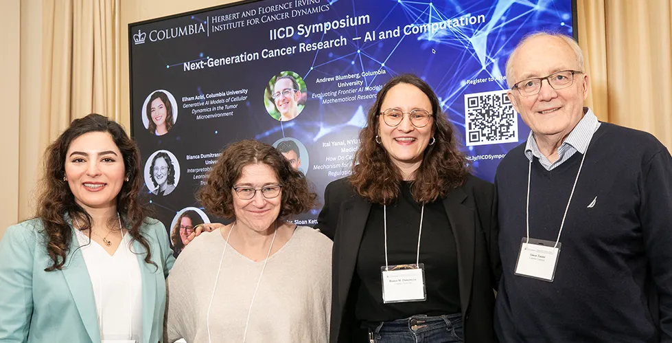 Speakers and IICD Director stand in front of a symposium poster.