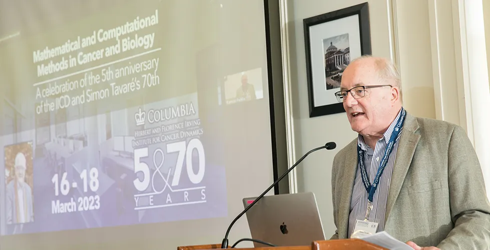 Simon Tavare presenting in front of a podium