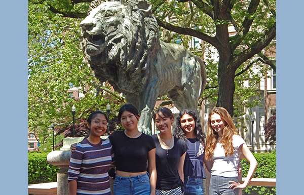 Group of five students in front of the Lion status on Columbia campus