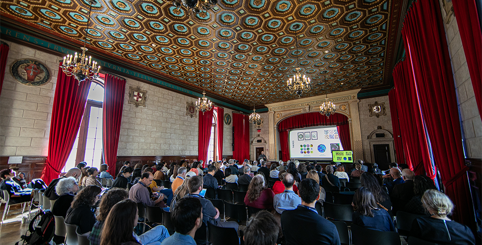 A person presenting at a podium in front of an audience.